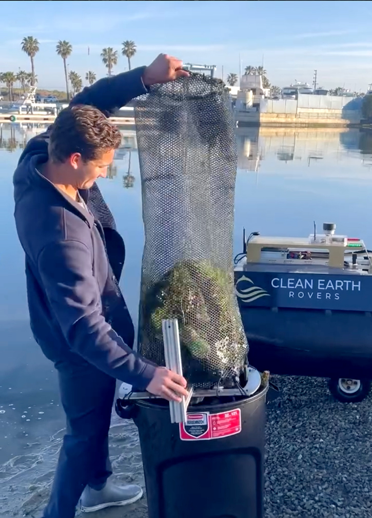 A person emptying a cage with trash and pollution that was collected by Crean Earth Rovers device.