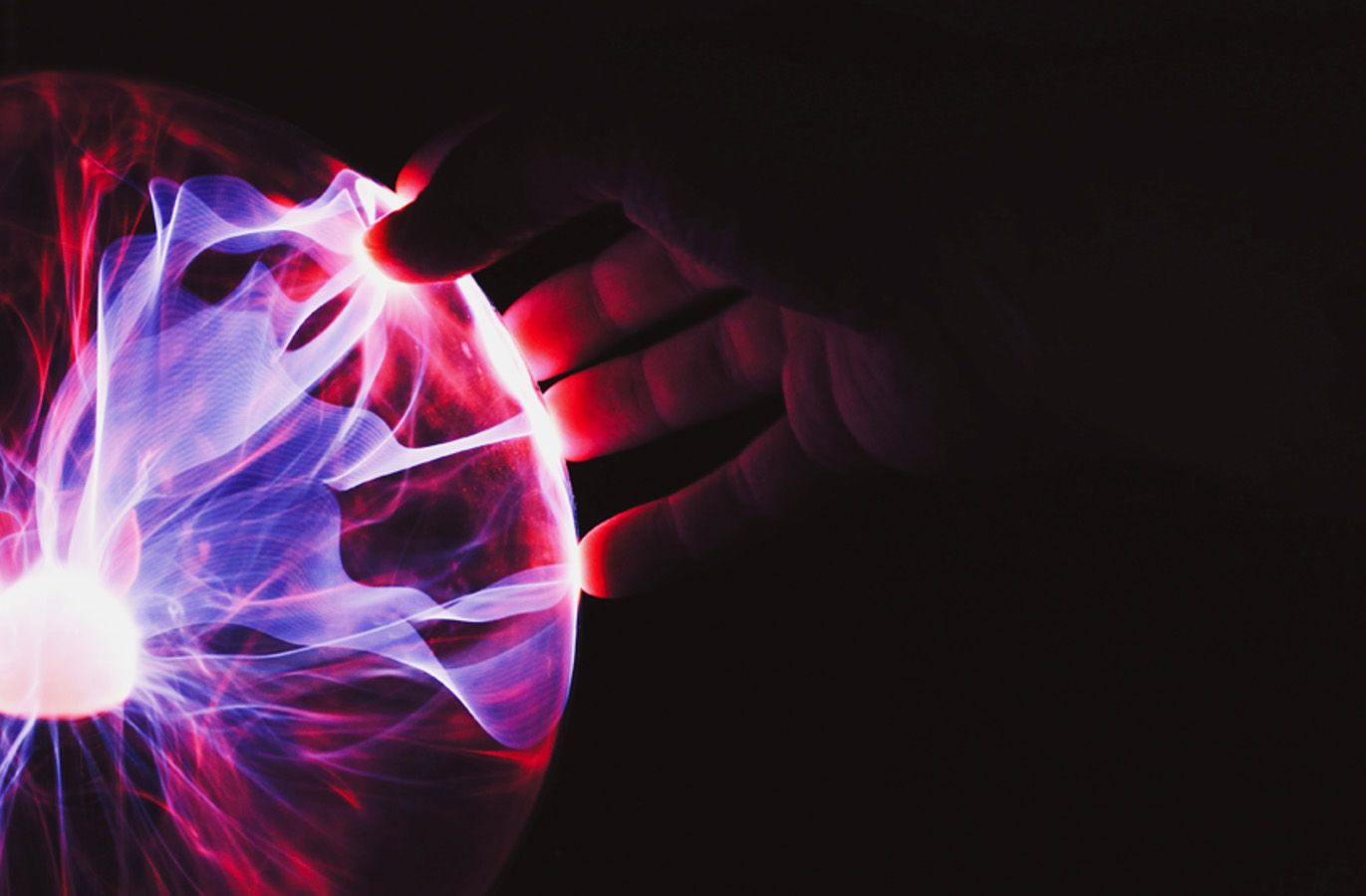 A hand's touching a plasma globe